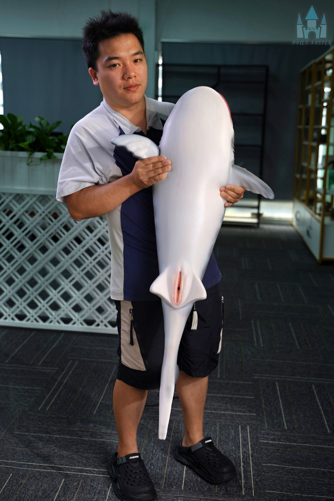 Shark Doll 110 cm est tenu dans les bras pour montrer la taille et les proportions, design de requin réaliste avec haut gris et bas blanc.